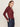 A woman with long light brown hair wears the Sanctuary Clothing dreamgirl lace button up night berry top and dark high-waisted jeans, hands in her pockets, standing against a plain light background.