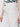 A person wears Sanctuary Clothing’s cruiser full length powdered sugar cargo pants with side pockets and a button closure, paired with a green and white patterned top. The image is cropped to show only the waist and upper thighs.