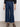 A person wears Sanctuary Clothing's league crop plot twist black textured long-sleeve shirt, paired with dark blue wide-leg jeans with front patch pockets and black strappy sandals, standing against a plain background.