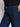 Wearing Sanctuary Clothing's league crop plot twist shirt, paired with high-waisted dark blue denim jeans featuring front patch pockets. The image shows the midsection and a hand resting on the hip.