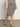 A woman wears the Sanctuary Clothing side slit midi black macrame stripe 2 skirt with a matching top and black sandals, standing on a gray floor against a plain light background.