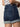 A person in Sanctuary Clothing's cuffed denim short dark with a leather patch and visible back pockets, paired with a striped top, stands in profile to showcase the side and back of their outfit.